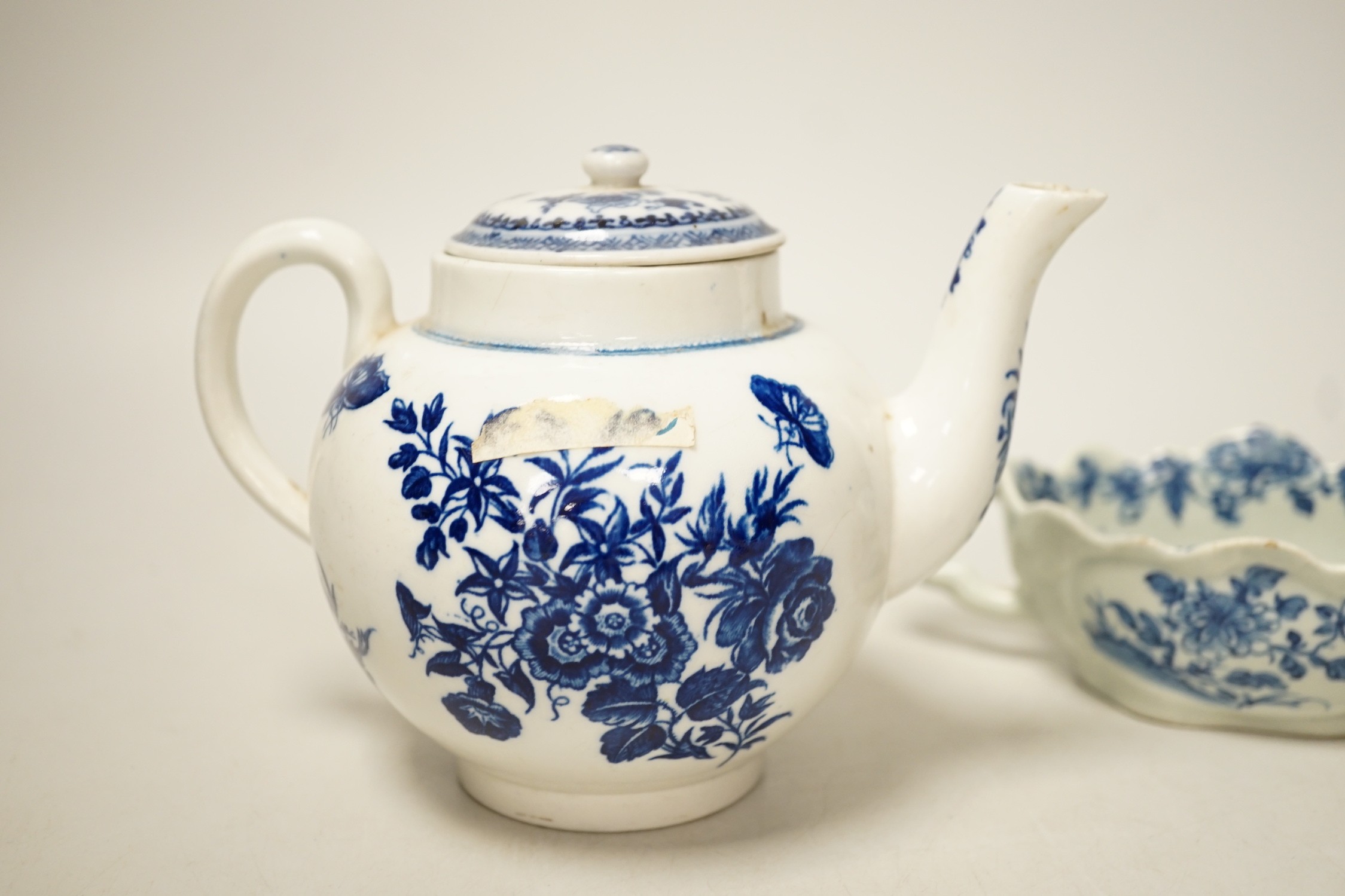 A Liverpool porcelain blue and white sauceboat and a Worcester teapot. Tallest 12cm